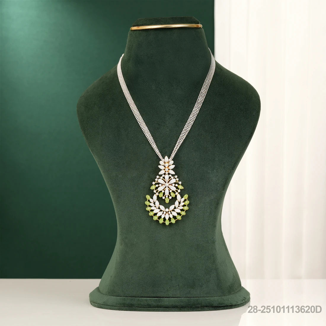 Necklace with a decorative pendant on a green mannequin against a green background